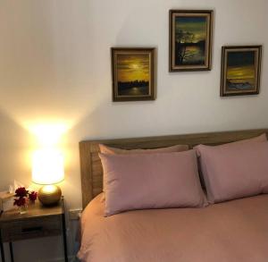 a bedroom with a bed with three pictures on the wall at Studio in the Rainforest in Kuranda