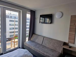 a bedroom with a couch and a tv and a window at Hotel Mercedes/Centrum in Hamburg