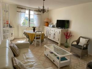 ein Wohnzimmer mit einem Sofa und einem Tisch in der Unterkunft Villa Provençale Le Mas Busien in La Motte