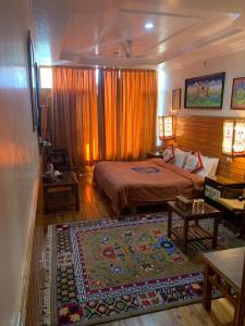 ein Schlafzimmer mit einem Bett und einem großen Teppich in der Unterkunft Auspiscious Him View Hotel in McLeod Ganj