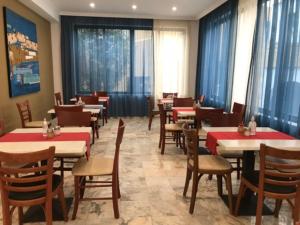 a dining room with tables and chairs and windows at Marina Sands in Agia Marina Nea Kydonias