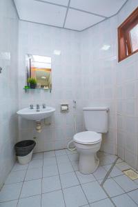 Baño blanco con aseo y lavamanos en Kijal Permai Apartment, en Kijal
