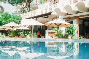 a hotel swimming pool with umbrellas and chairs at iRoHa Garden Hotel & Resort in Phnom Penh