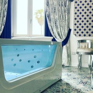 y baño con bañera y cortinas azules. en Mirage Rooms, en Anzio