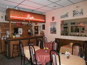 マントンにあるオテル クラリッジズのテーブル付きのレストラン、看板のあるバー