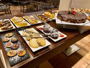 リミニにあるホテル プリンチペ ディ ピエモンテの様々なペストリーやケーキを取り揃えたビュッフェ