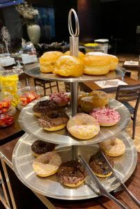 three tiers of donuts and donuts on a table at Hotel Principe di Piemonte in Rimini