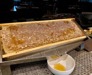 a container filled with honey next to a bowl of honey at Hotel Principe di Piemonte in Rimini