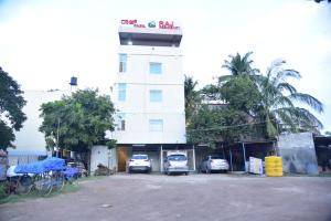 un edificio con coches estacionados en un estacionamiento en Raj Residency Mysuru, en Mysore