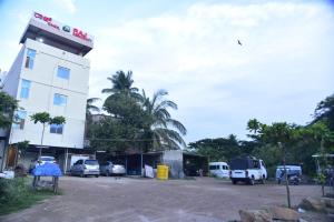 un edificio con coches estacionados en un estacionamiento en Raj Residency Mysuru, en Mysore