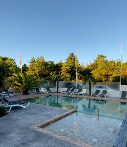 a large swimming pool with lounge chairs and trees at Camping La Forêt in Saint-Jean-de-Monts