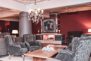 sala de estar con sofás, mesa y chimenea en Q! Hotel Maria Theresia, en Kitzbühel