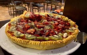 a pizza sitting on top of a plate on a table at Hotel Principe di Piemonte in Rimini