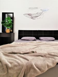 una camera da letto con un letto con una coperta e una pianta di Embun Sky Cottage - Kota Bharu, WIFI, 6 - 8 Pax a Kota Bharu
