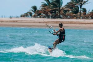 a person on a surfboard in the water at Pousada Casa Suiça in Itarema