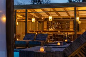 a restaurant with tables and chairs and a bar at Skiathos Theros, Philian Hotels and Resorts in Skiathos