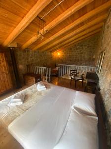 a large white bed in a room with wooden ceilings at Angelic in the mountains in Kaisárion