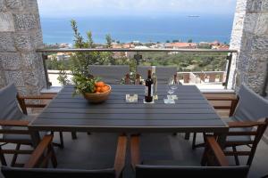 een tafel met een schaal sinaasappels en wijnglazen op een balkon bij Villa Dafni in Kalamata