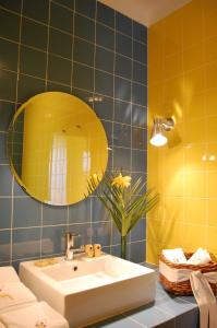 a bathroom with a sink and a yellow mirror at Outeiro Da Vila - Casas De Campo in Vila Verde de Ficalho