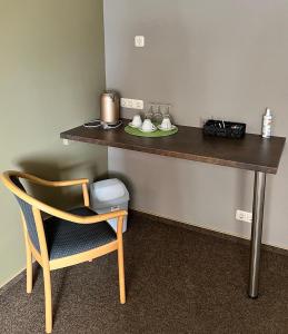 einen Schreibtisch mit einem Stuhl, einem Tisch und einem Tisch in der Unterkunft Hostel Fehmarn Mehrbett-Zimmer in Fehmarn
