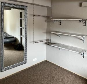 einen begehbaren Kleiderschrank mit einem Spiegel und einem Bett in der Unterkunft Hostel Fehmarn Mehrbett-Zimmer in Fehmarn