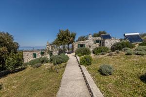 un camino que conduce a una casa de piedra con techo solar en Vila Scripea en Škrip