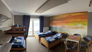 um quarto com beliches e uma pintura na parede em Hostel Fehmarn Ferienwohnung em Fehmarn