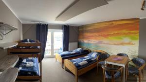 a room with bunk beds and a painting on the wall at Hostel Fehmarn Ferienwohnung in Fehmarn