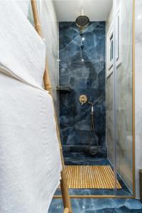 een badkamer met een douche met blauwe tegels bij Home is in Thessaloniki