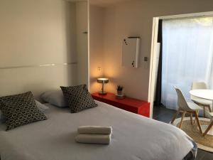 a bedroom with a bed with two pillows and a table at Le Ponant, Wifi, Piscine, Parking in La Grande-Motte