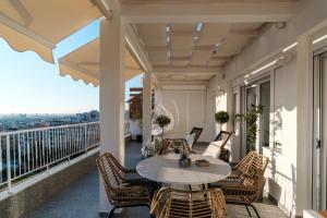 a patio with a table and chairs on a balcony at Home is in Thessaloniki