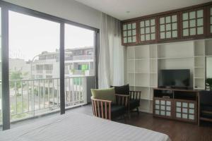 a hotel room with a bed and a television and a balcony at Halong & Me Hometel Double Room in Ha Long