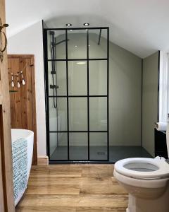 a bathroom with a glass shower and a toilet at Spaven Mor, Near Penzance Stations, 3 bedroom home in Penzance