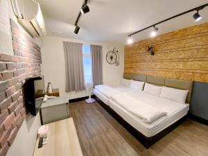 sypialnia z białym łóżkiem i ceglaną ścianą w obiekcie Fengjia dream house w mieście Taizhong