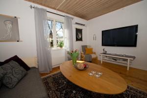 uma sala de estar com uma mesa de centro e uma televisão de ecrã plano em Naturskönt boende nära Skövde em Skövde