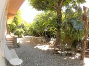 a group of chairs and tables under a tree at La Villa Carcassonne, Chambres d hôtes, B&B, face à la Cité Médiévale in Carcassonne