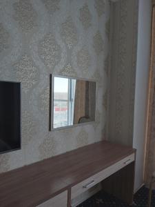 a mirror on a wall next to a tv at "Palazzo" in Kostanay