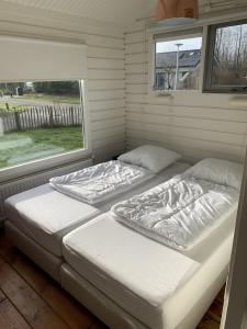 dwa łóżka w pokoju z oknem w obiekcie Lauwersmeer 120 w mieście Lauwersoog