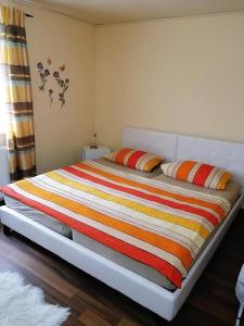 ein Bett mit einer bunten Decke auf einem Zimmer in der Unterkunft Ferienwohnung Familie Ober in Rotthalmünster