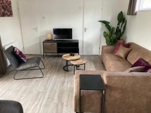 a living room with a couch and a table at Vakantiecentrum De Ullingse Bergen in Sint Anthonis