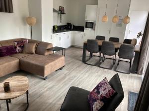 Sint Anthonis的住宿－卑爾根假日公寓，客厅配有沙发和桌子