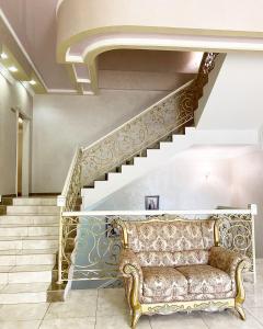 a living room with a couch and stairs at "Palazzo" in Kostanay