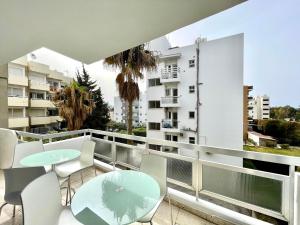 a balcony with tables and chairs and a building at 100 m to the beach Sea La Vie 3 bedroom Apartment in Limassol