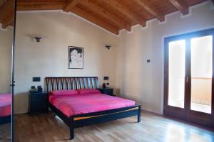 a bedroom with a bed with pink sheets and a window at Guesthouse "Villa Tamas" in Limone sul Garda