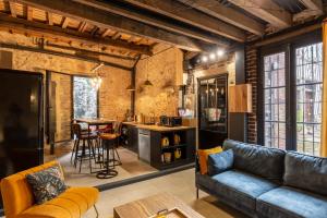 ein Wohnzimmer mit einem Sofa und einem Tisch in der Unterkunft L'Atelier d'Eléa - 4 - Terrace - Indus-chic in the heart of Honfleur - 6 P in Honfleur