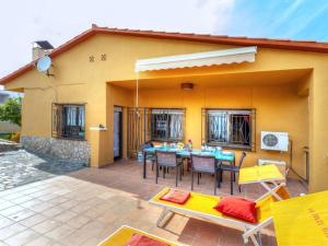 a patio with a table and chairs in front of a house at VILLA BLANCA 10 minutos de la Playa Costa brava in Maçanet de la Selva