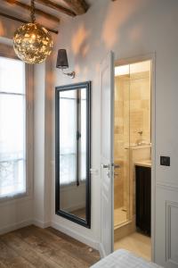 a bathroom with a sink, shower, and a window at Hotel Saint-Louis en L'Isle in Paris