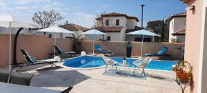 Un patio con sillas y una piscina. en Chambre d'hôtes dans Villa Diane, en La Londe-les-Maures