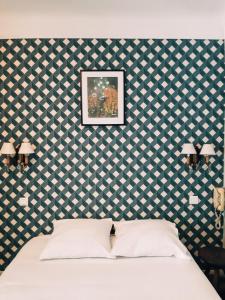 a bedroom with a white bed with a blue and white wallpaper at Saint Charles Hôtel & Coliving Biarritz in Biarritz