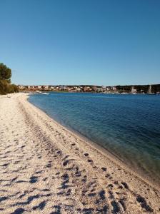 una playa con huellas en la arena y el agua en Luxury home Alpha, pool, camp Volme - nearby Kamenjak, en Banjole
